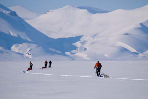 Skieurs tirant des traîneaux dans la neige